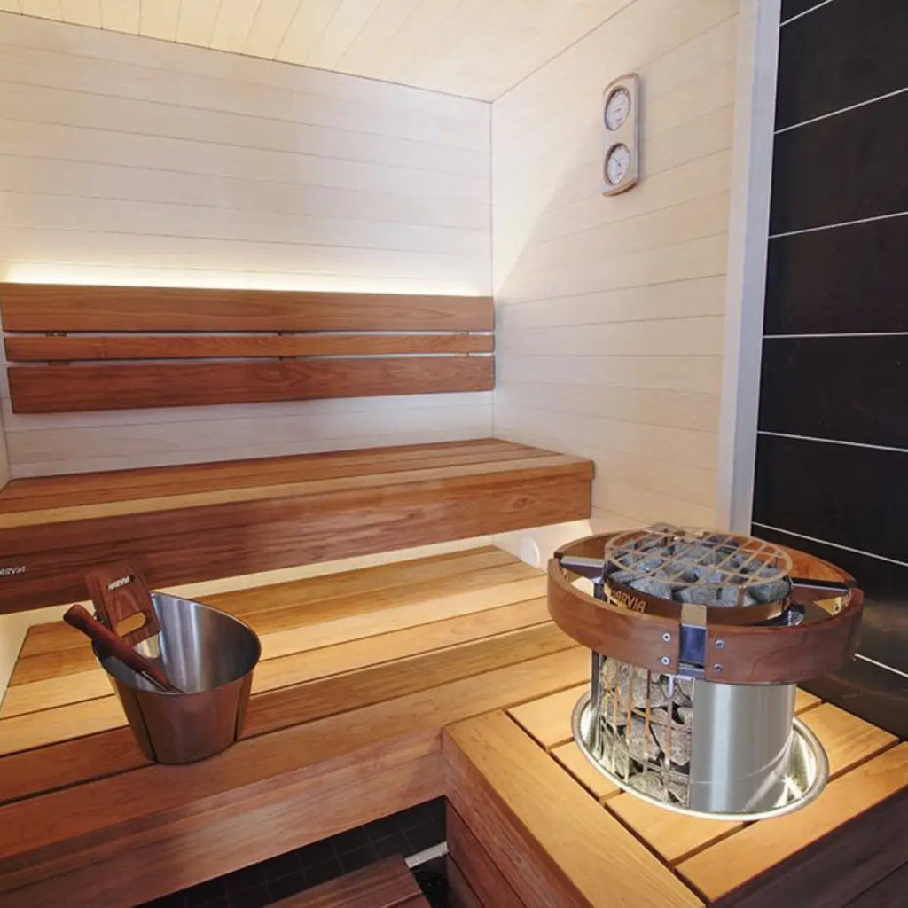 Wooden sauna interior with benches and a metal bucket by Finnish Sauna Builders