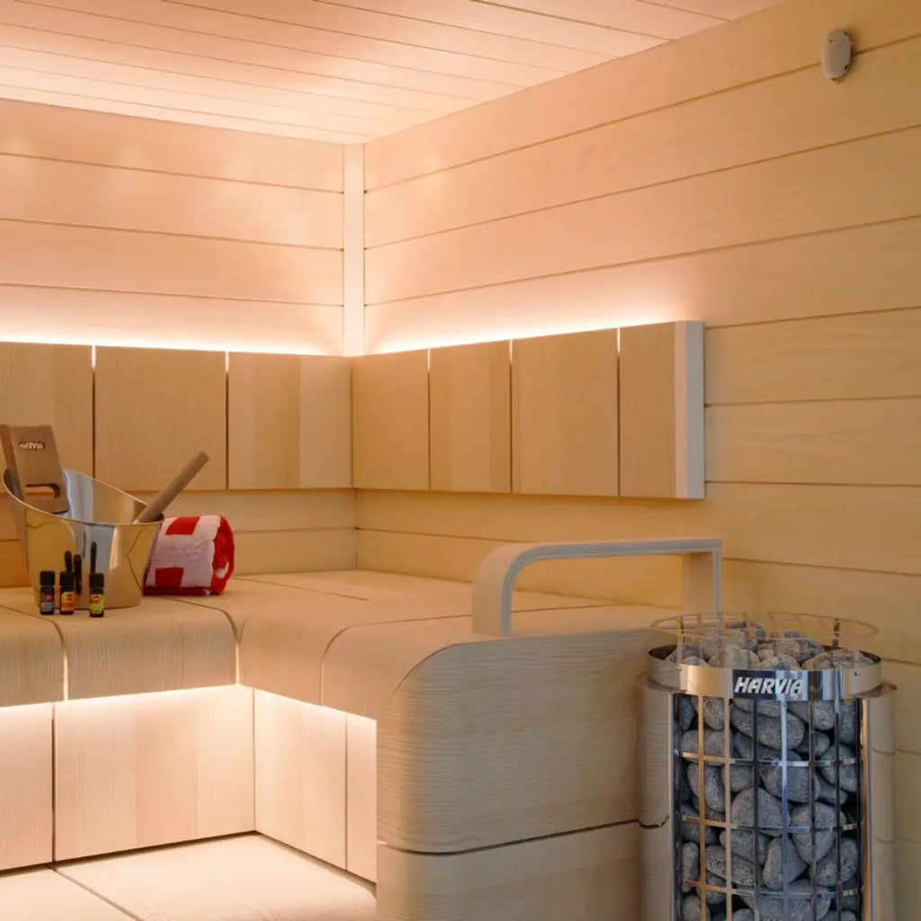 Modern sauna interior with wooden walls and a Harvia sauna heater by Finnish Sauna Builders