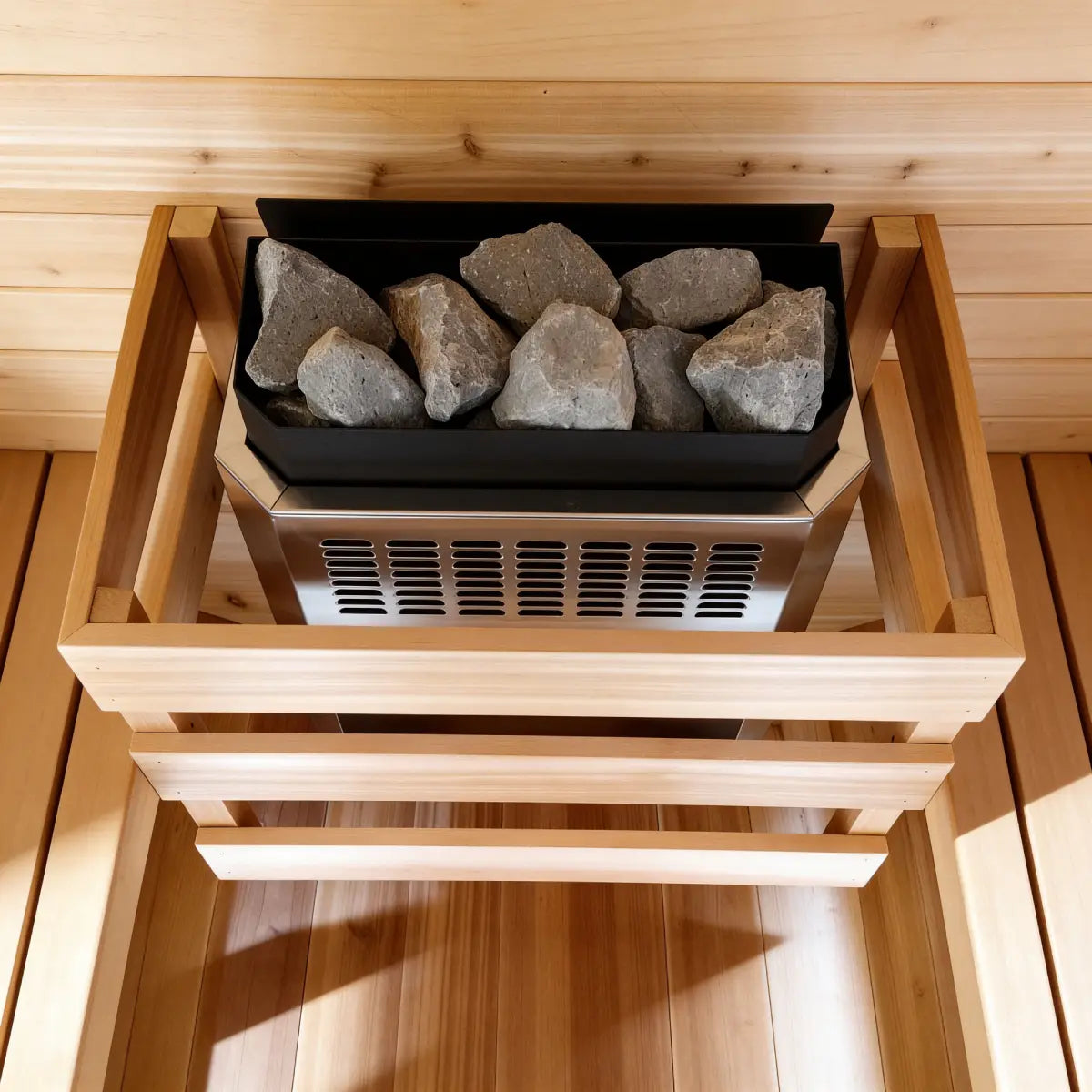 Homecraft H-Series Electric Sauna Heater Wooden sauna stove with stones inside, set against a wooden interior.