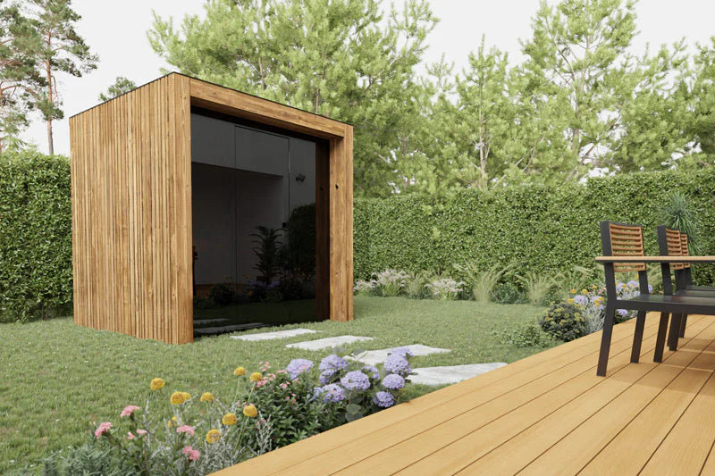 Wooden garden shed in a garden setting with a deck and flowers.